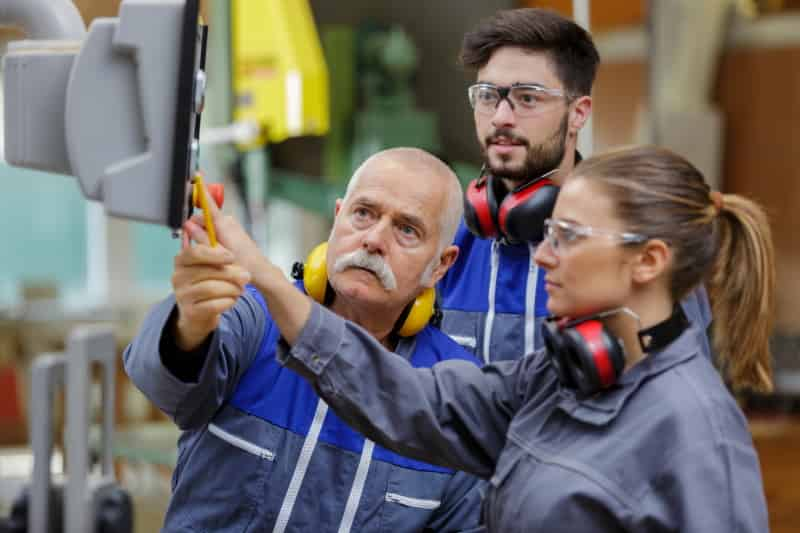 Apprentis aux commandes d'une machine outils


